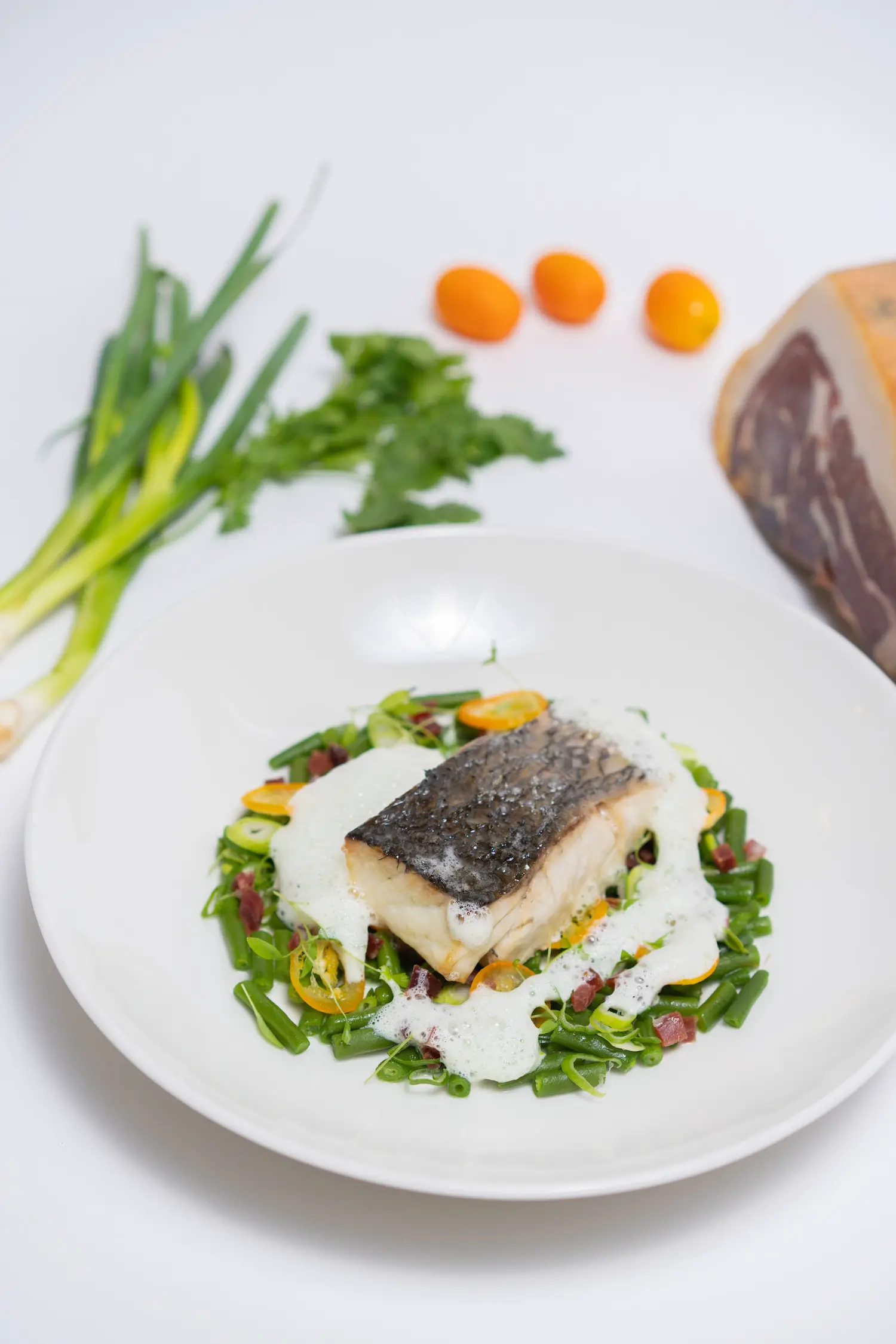 Filets de lieu jaune haricots au Jabugo et oignons nouveaux, sauce émulsionnée à la coriandre